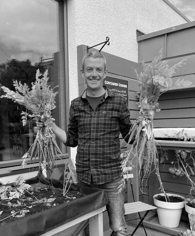 Michael Kelly Holding 2 bunches of carrots